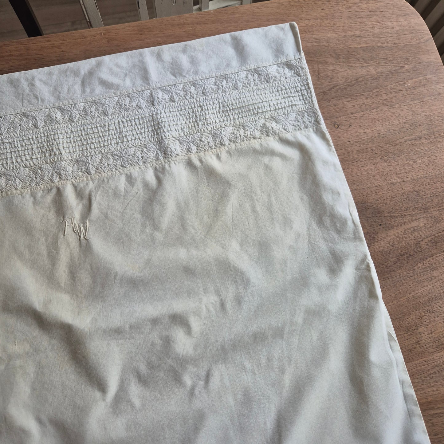 Stark vergilbter Kopfkissenbezug mit Monogram A.W. 75x70cm