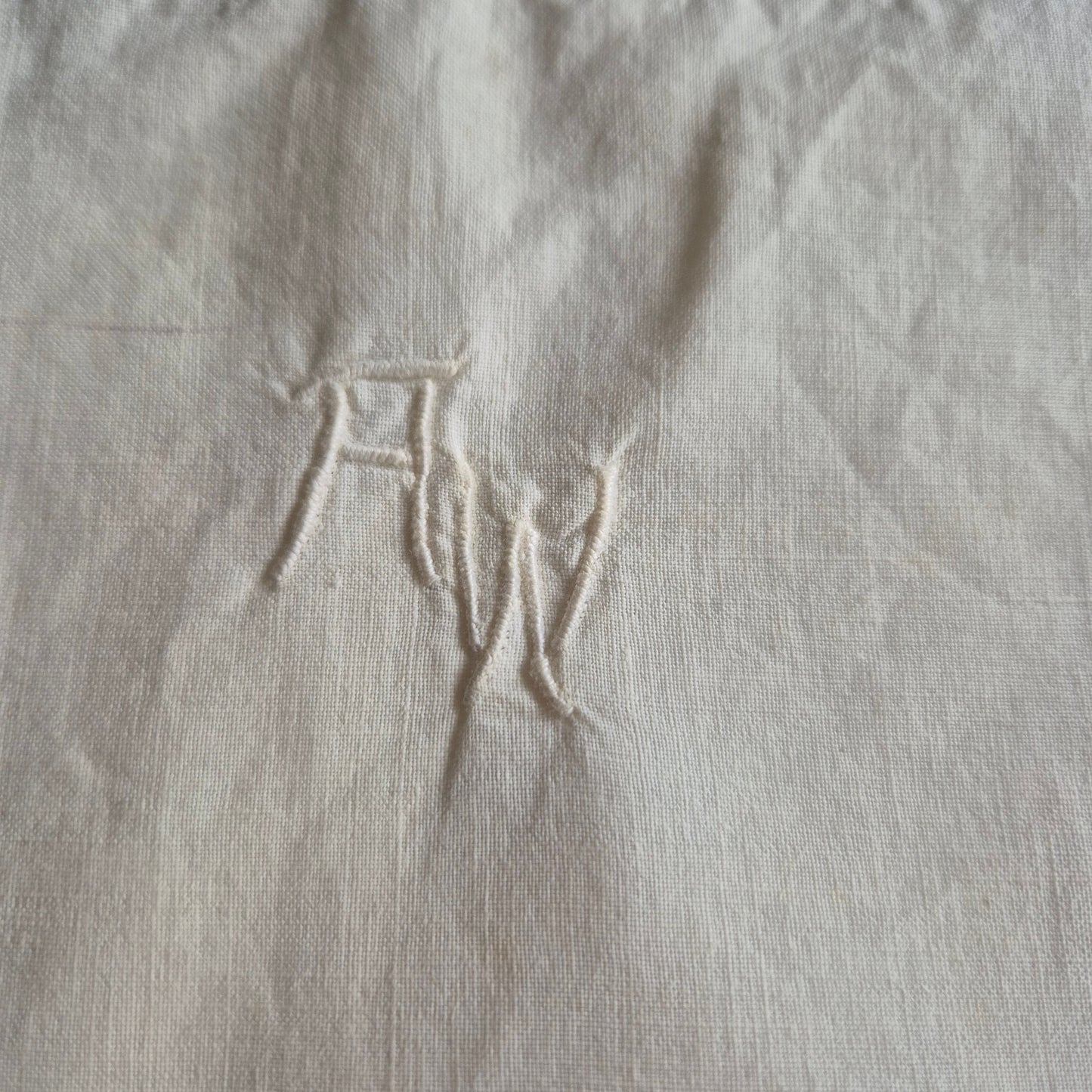 Stark vergilbter Kopfkissenbezug mit Monogram A.W. 75x70cm