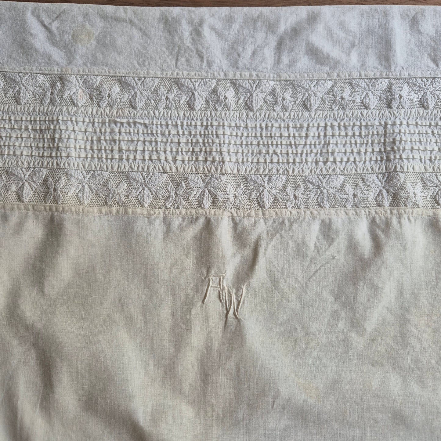 Stark vergilbter Kopfkissenbezug mit Monogram A.W. 75x70cm