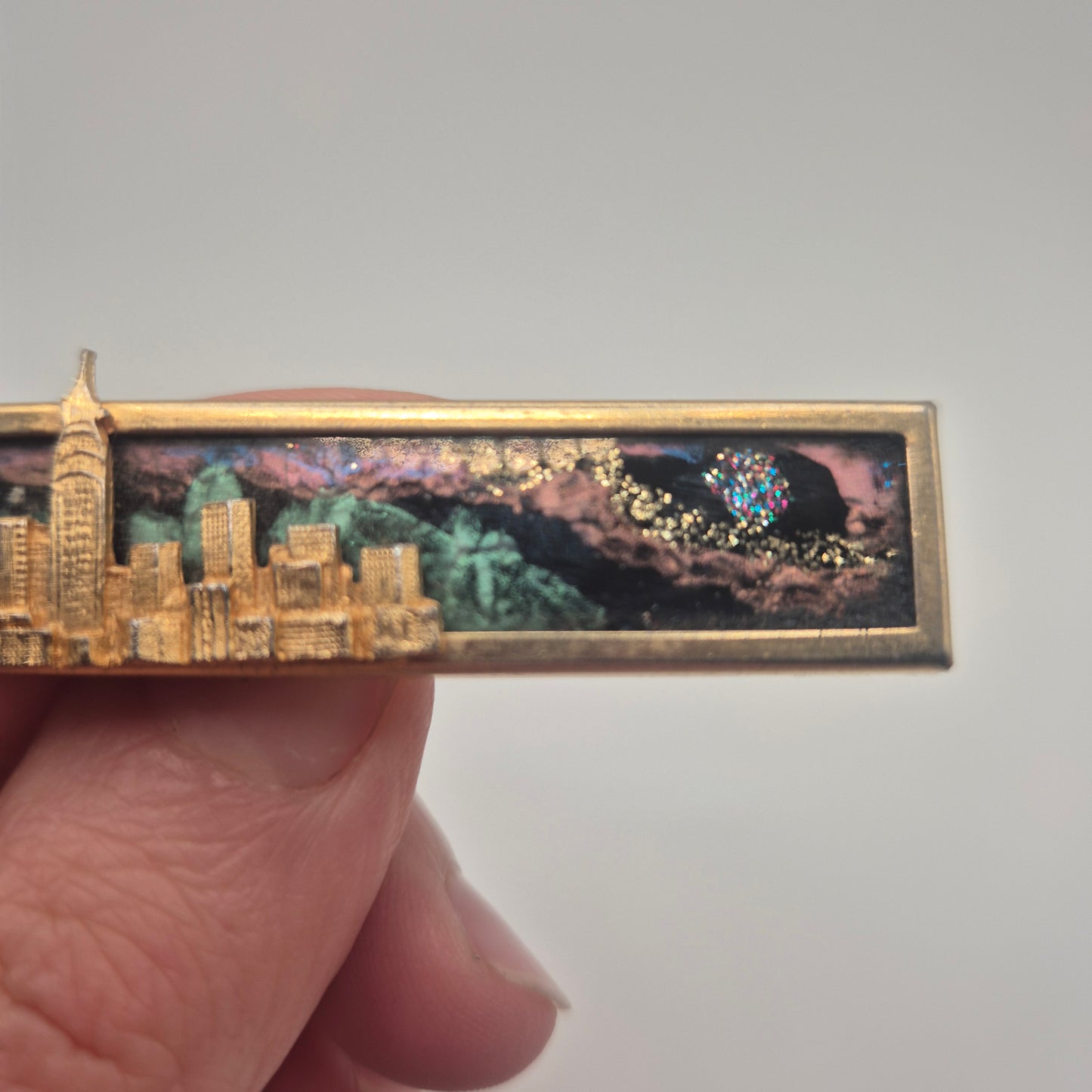 Vintage-Brosche – Goldene Skyline vor kosmischem Hintergrund New York