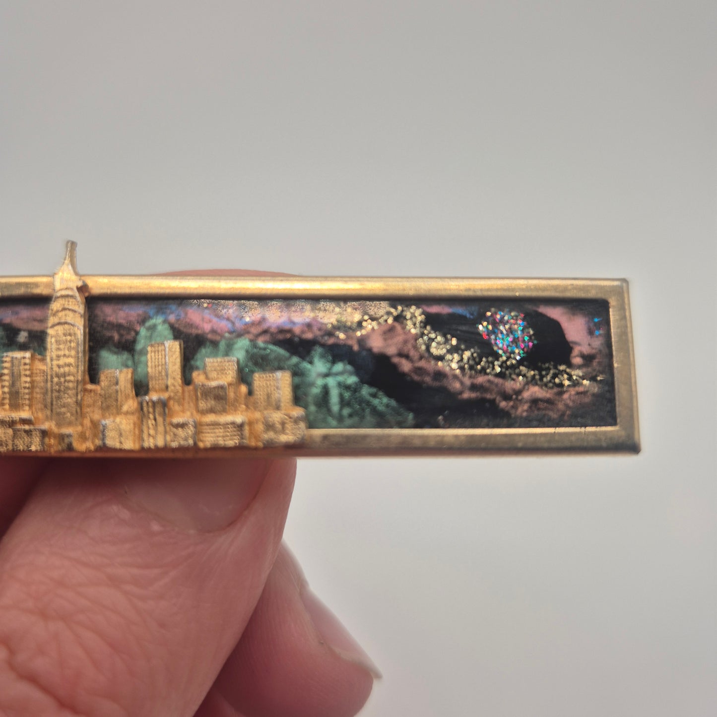 Vintage-Brosche – Goldene Skyline vor kosmischem Hintergrund New York