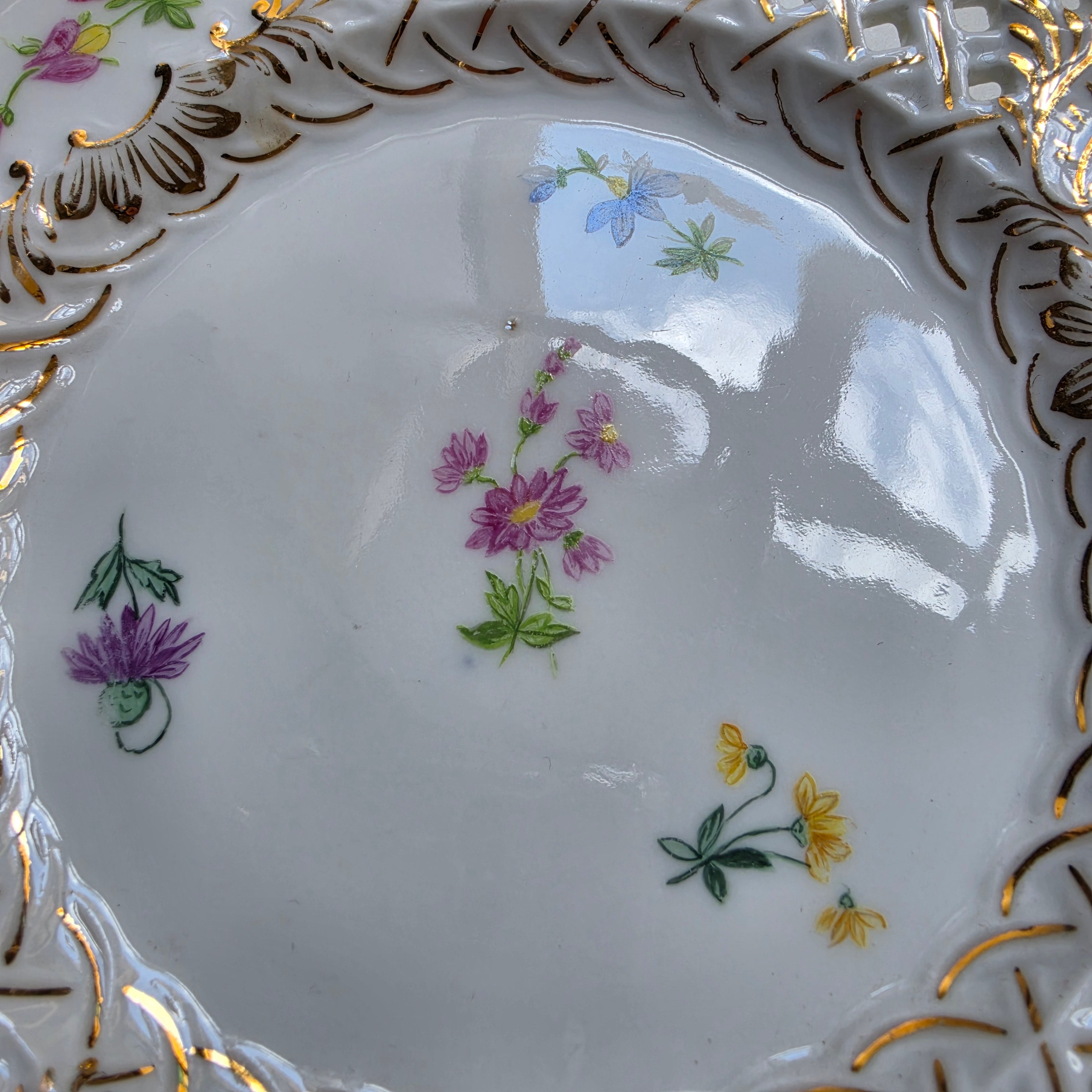 Antiker Durchbruchteller mit handgemalten Blumen – um 1900