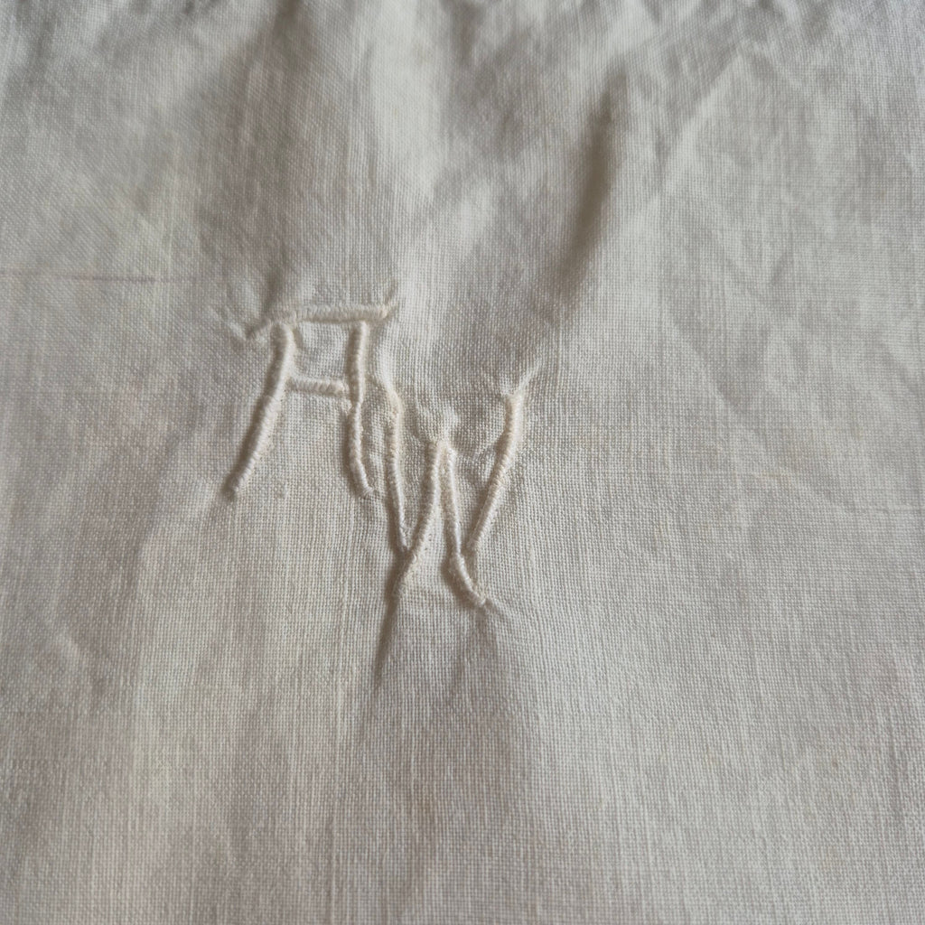 Stark vergilbter Kopfkissenbezug mit Monogram A.W. 75x70cm