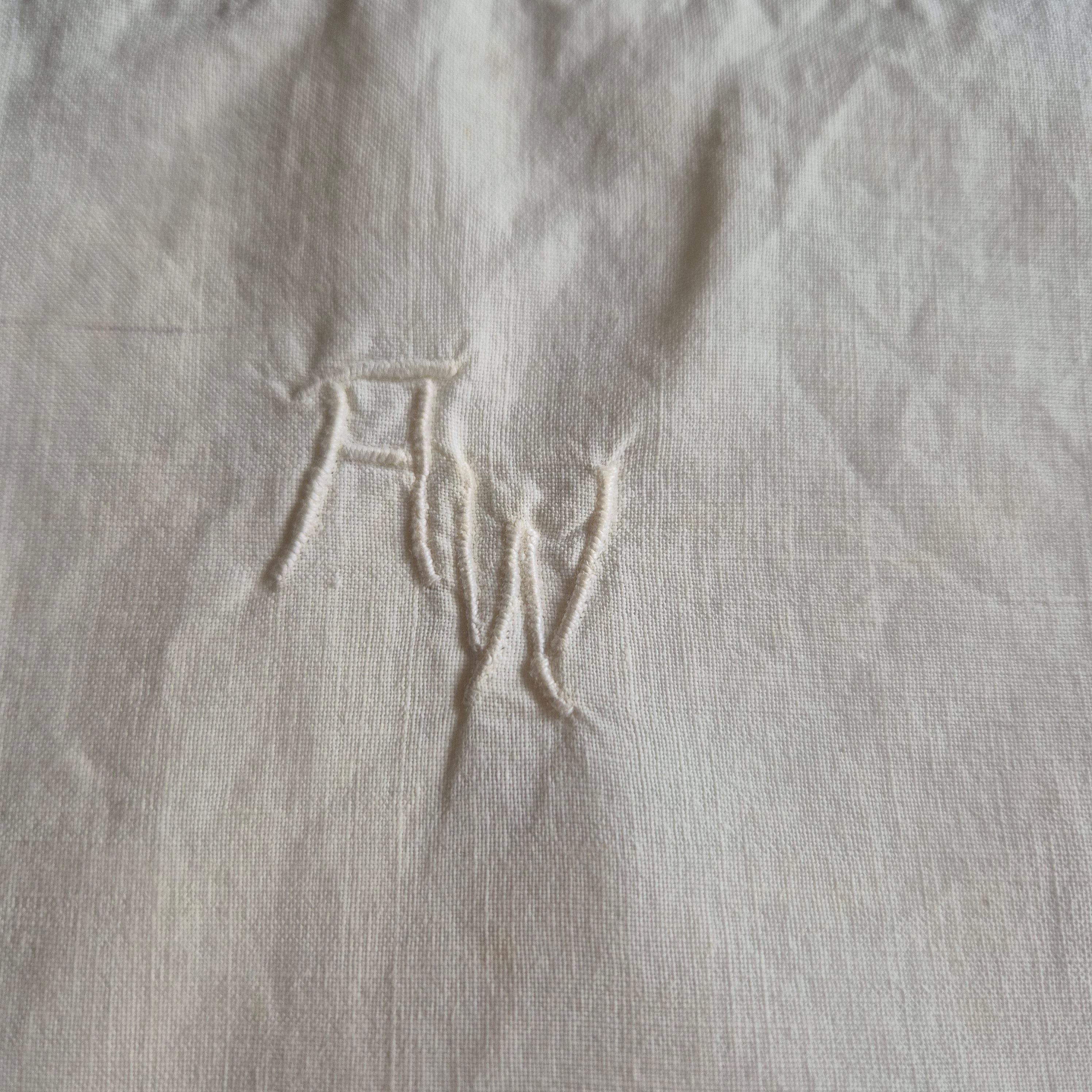 Stark vergilbter Kopfkissenbezug mit Monogram A.W. 75x70cm