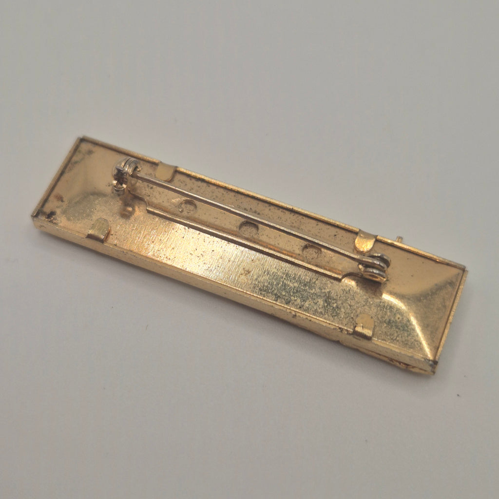 Vintage-Brosche – Goldene Skyline vor kosmischem Hintergrund New York