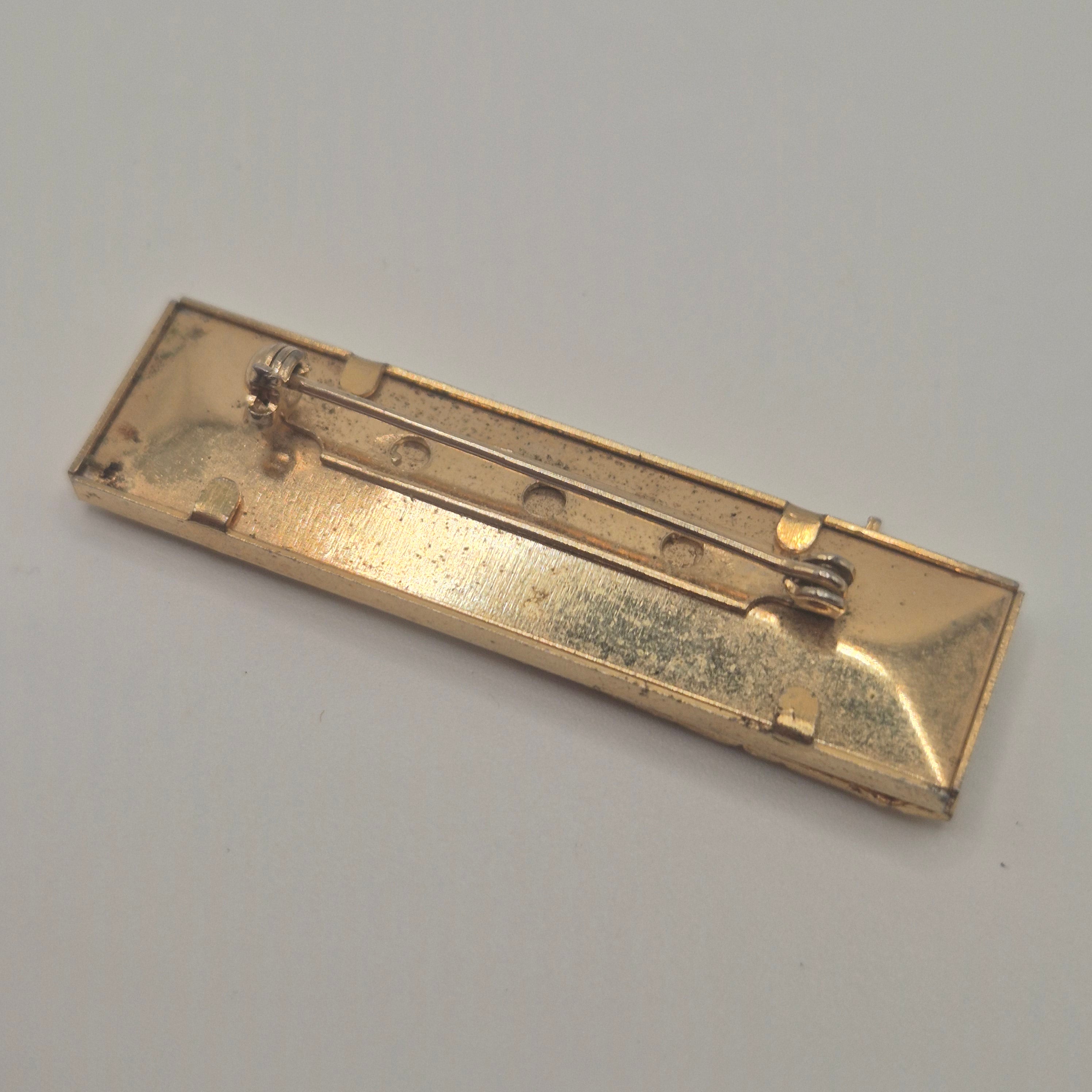 Vintage-Brosche – Goldene Skyline vor kosmischem Hintergrund New York